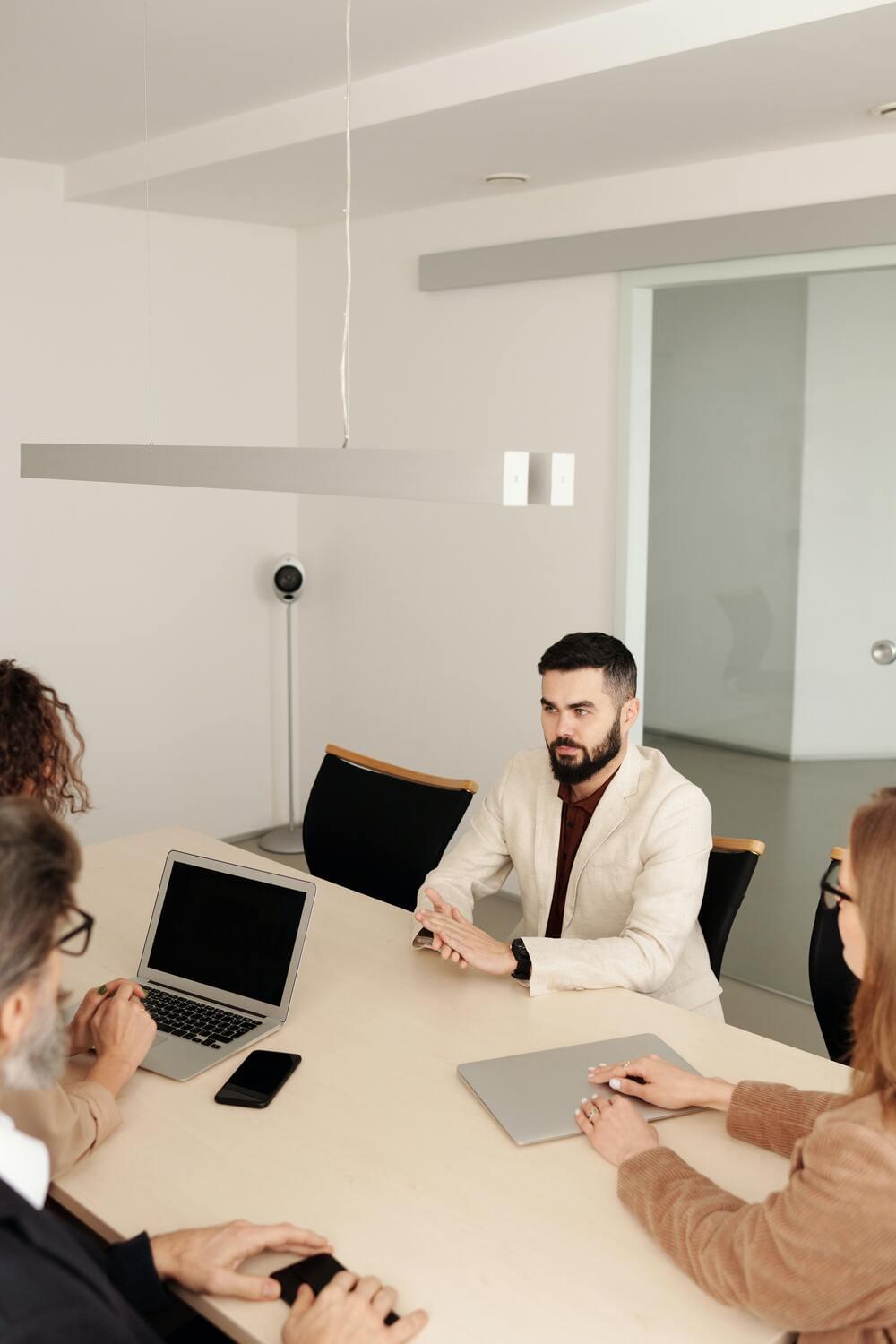 Free Man in White Suit Jacket Sitting Having an Interview